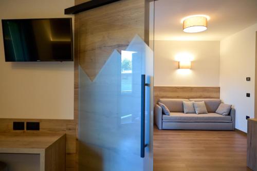 a living room with a couch and a glass door at Hotel Rio in Caderzone