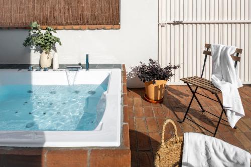 bañera de hidromasaje en un patio con silla en Magno Apartments Robles with Bath Tub and Private Parking en Sevilla