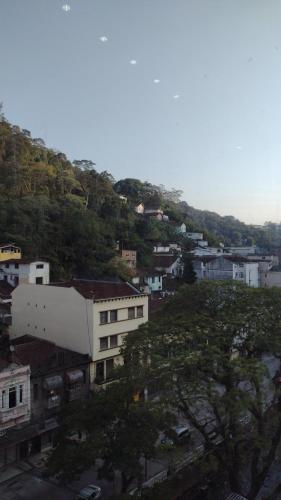 eine Stadt mit einem Hügel mit Gebäuden und Bäumen in der Unterkunft Flat na 16 de março, centro Historico de Petropolis in Petrópolis