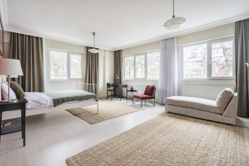 ein Schlafzimmer mit einem Bett, einem Sofa und Fenstern in der Unterkunft Modern Flat with Balcony on Bagdat Street in Istanbul