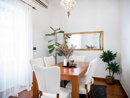 a dining room table with white chairs and a mirror at The Arcade in Athens