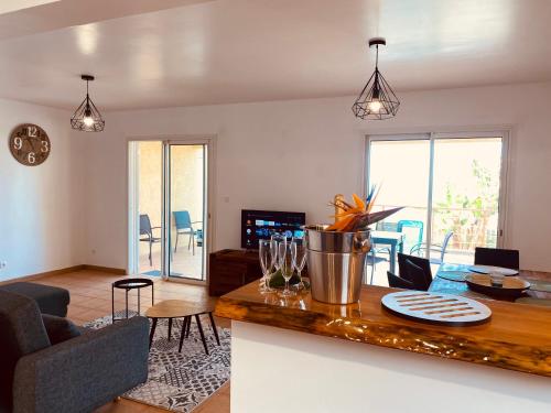 cocina y sala de estar con mesa y sillas en La Caza Léo - 120m² - Piscine vue sur mer en Étang-Salé