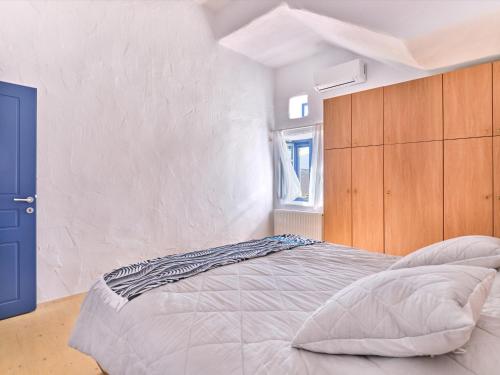 1 dormitorio con 1 cama grande y armario de madera en Nola Traditional Villa with pool and amazing sea views, Paros, en Kampos