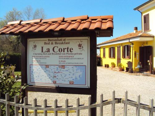 a sign in front of a building with a fence at Casa di Campagna B&B La Corte Ferrara in Ferrara