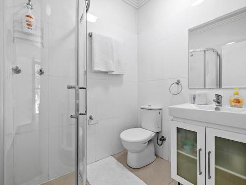 a bathroom with a shower and a toilet and a sink at Sunny Rooms Mascot in Sydney