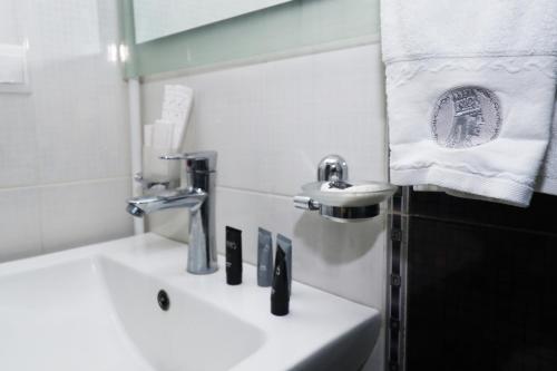 a white bathroom with a sink and a mirror at Hotel Tigran Mets Yerevan in Yerevan