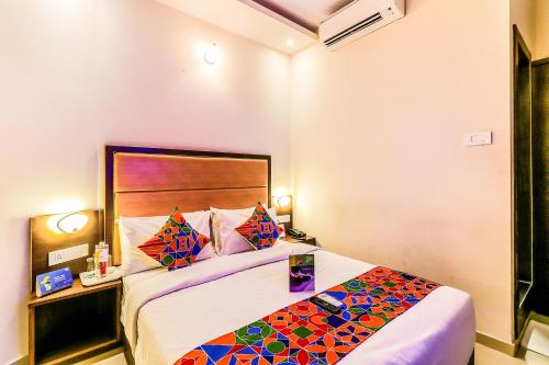 a hotel room with a large bed with colorful pillows at FabHotel Admiral in Mumbai