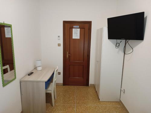 a room with a desk and a television and a door at Affittacamere Pratello 97 in Bologna