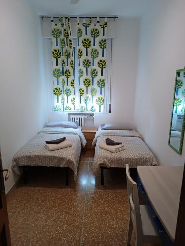 a room with two twin beds and a window at Affittacamere Pratello 97 in Bologna