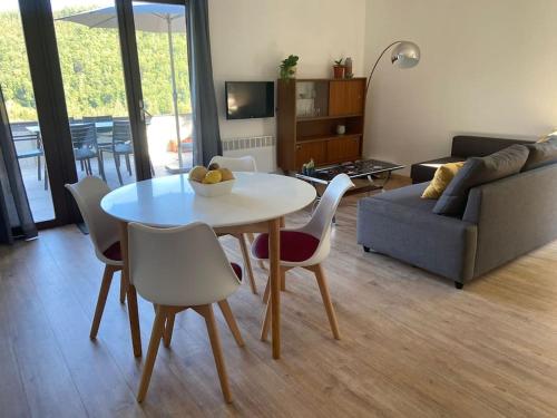 a living room with a table and chairs and a couch at Les 3 Frères : plain-pied en pleine nature in Vresse-sur-Semois
