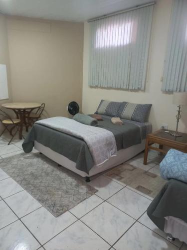 1 dormitorio con cama, mesa y sidra de mesa en Loft Jardim Botânico 2 en Curitiba