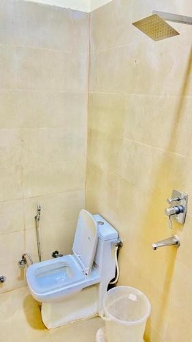 a bathroom with a toilet and a sink at The Miraj Hotel in Murthal