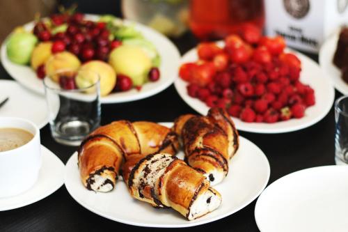 a table topped with plates of pastries and fruit at Hotel Tigran Mets Yerevan in Yerevan