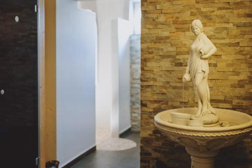 a statue of a woman sitting on top of a fountain at Appartements Sulzer by we rent, SUMMERCARD INCLUDED in Zell am See