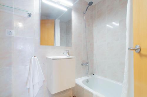 bagno bianco con doccia, vasca e lavandino di Budget Beach Studio 22 a Sant Antoni de Calonge