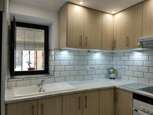 a kitchen with a sink and a window at La casa del barrio in Mijas