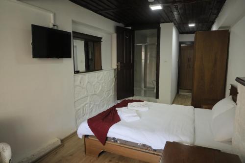 a bedroom with a bed with a tv on the wall at SALİH BEY KONAĞI in Amasya