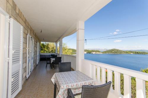 a balcony with a table and chairs and a view of the water at Apartment Ruza in Sobra
