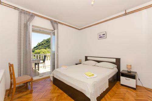 ein Schlafzimmer mit einem Bett und einem großen Fenster in der Unterkunft Apartment Ruza in Sobra
