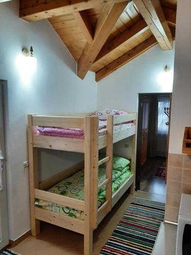 a bedroom with bunk beds in a room with wooden ceilings at Casuta Pietrosul Rodnei in Borşa