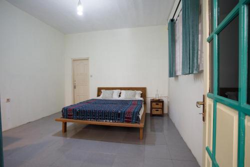 a bedroom with a bed and a tv in it at Rumah Kalpataru in Yogyakarta