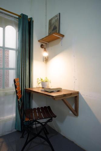 a wooden table and a chair in a room at Rumah Kalpataru in Yogyakarta