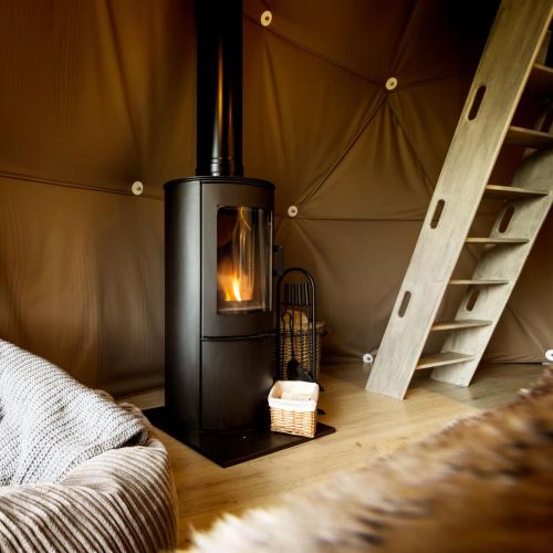 a fireplace in a room with a yurt at Luna Domes in Chiddingstone