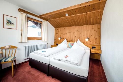 a bedroom with a large bed in a room at Pension der Steinbock - das 300 Jahre alte Bauernhaus - TIROL in Sankt Anton am Arlberg