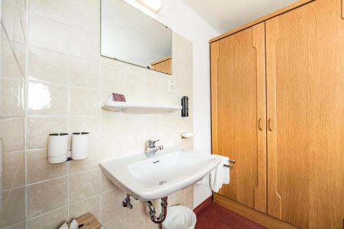 a bathroom with a sink and a mirror at Pension der Steinbock - das 300 Jahre alte Bauernhaus - TIROL in Sankt Anton am Arlberg