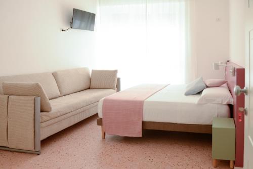 un soggiorno con letto e divano di La Rosa rooms & holiday home a Porto SantʼElpidio