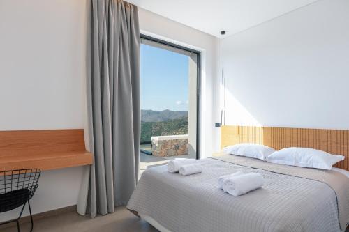 a bedroom with a bed and a large window at Villa Anasa in Palaiochóra