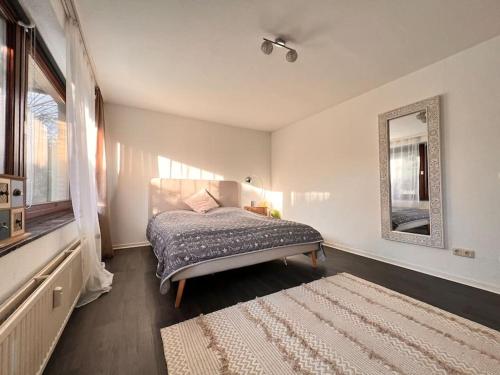 a bedroom with a bed and a mirror and a rug at Exclusive Maisonette 90qm Parkplatz Balkon Citynah in Seevetal