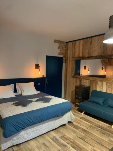 une chambre avec un lit et un canapé bleu dans l'établissement Domaine du Serre d'Avène, à Saint-Christol-lès-Alès