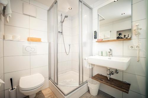 a bathroom with a shower and a toilet and a sink at Pension der Steinbock - das 300 Jahre alte Bauernhaus - TIROL in Sankt Anton am Arlberg