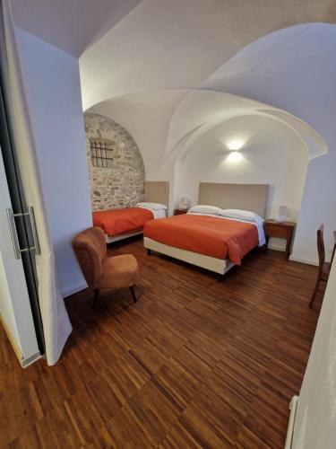 a hotel room with two beds and a chair at Hotel Raibl e Appartamenti in Tarvisio