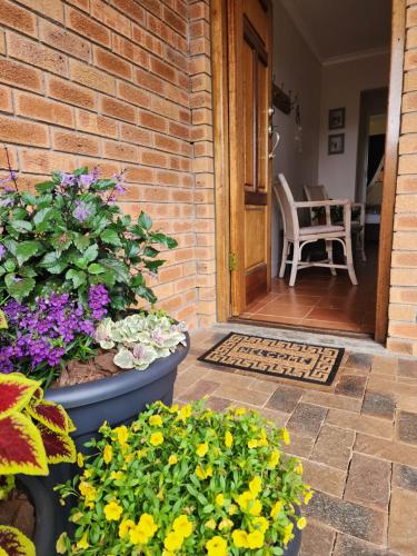 a brick house with flowers in front of a door at Little Greece in Cape Town