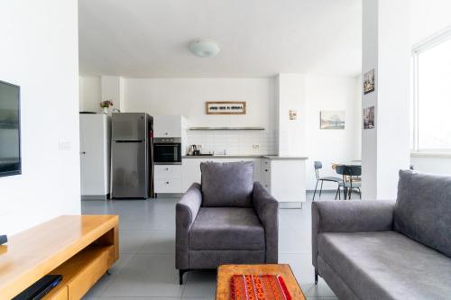 a living room with a couch and a kitchen at Ziv Apartments - Hayarkon 196 in Tel Aviv