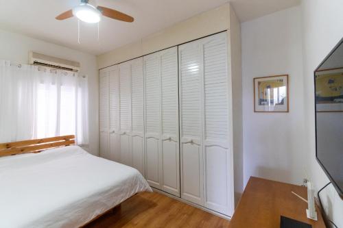 a bedroom with a bed and a large closet at Ziv Apartments - Hayarkon 196 in Tel Aviv