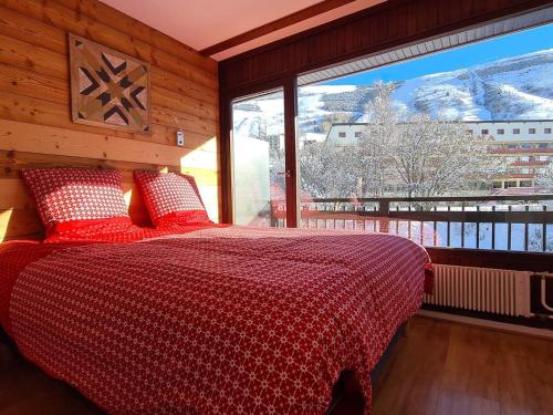 a bedroom with a bed and a large window at Appartement Les Deux Alpes, 2 pièces, 4 personnes - FR-1-516-200 in Les Deux Alpes