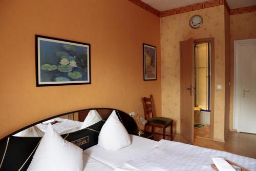 Hotel Sessellift في كوبلنز: غرفة نوم بسرير وساعة على الحائط