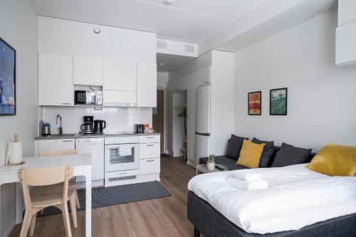 ein Wohnzimmer mit einem Bett und eine Küche in der Unterkunft Hiisi Homes Järvenpää in Järvenpää
