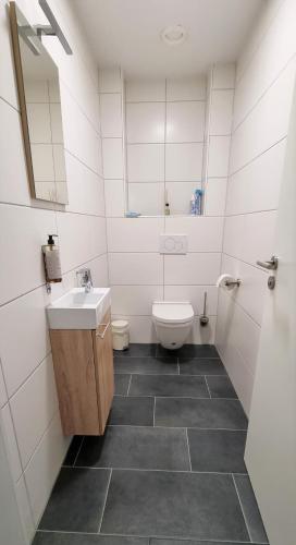 a white bathroom with a sink and a toilet at Flat11 4-Zi Wohnung Messe Karlsruhe in Rheinstetten