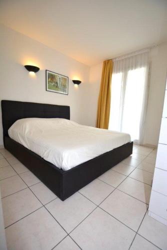 une chambre avec un grand lit dans une pièce dans l'établissement Palais des Domes Piscine et Parking, à Nice