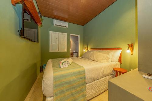 a small bedroom with a bed and a table at EcoCharme Pousada Varandinha in Fernando de Noronha