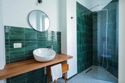 uma casa de banho com um lavatório e um chuveiro com um espelho. em Il Canto di Ligea em Lamezia Terme