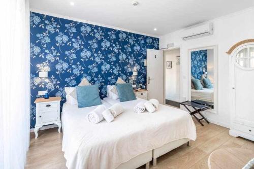 una camera da letto con un grande letto bianco e carta da parati blu di Lisbon Terrace Suites Special for Groups a Lisbona