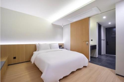 a large white bed in a large room at Hotel TARA in Seoul