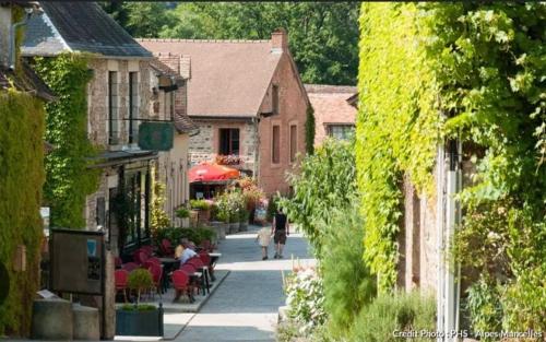 Une rue dans une petite ville avec des gens assis à table dans l'établissement T1 refait à neuf, à Aleçon