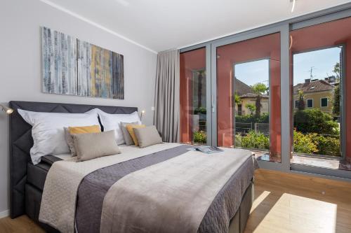 een slaapkamer met een groot bed en grote ramen bij Luxury City Center Apartment -50m to the sea in Opatija