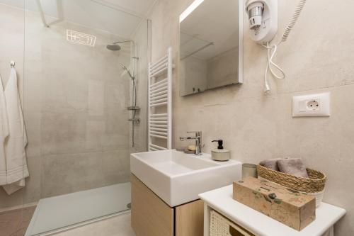 La salle de bains est pourvue d'un lavabo et d'une douche. dans l'établissement Luxury City Center Apartment -50m to the sea, à Opatija
